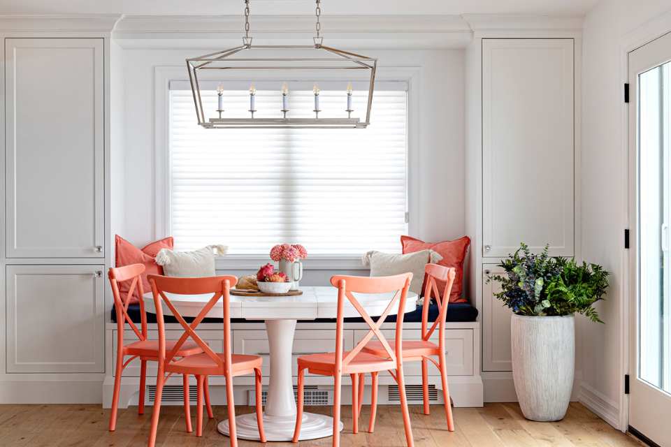 breakfast nook in designer home with bold peach throws and accent chairs